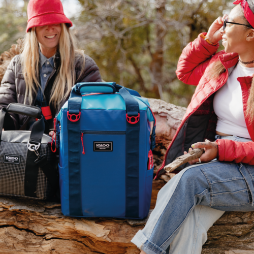 dos mujeres hablando en la naturaleza con dos bolsas térmicas 