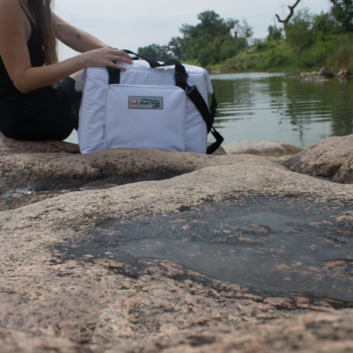 mujer con una bolsa térmica blanca en el rio